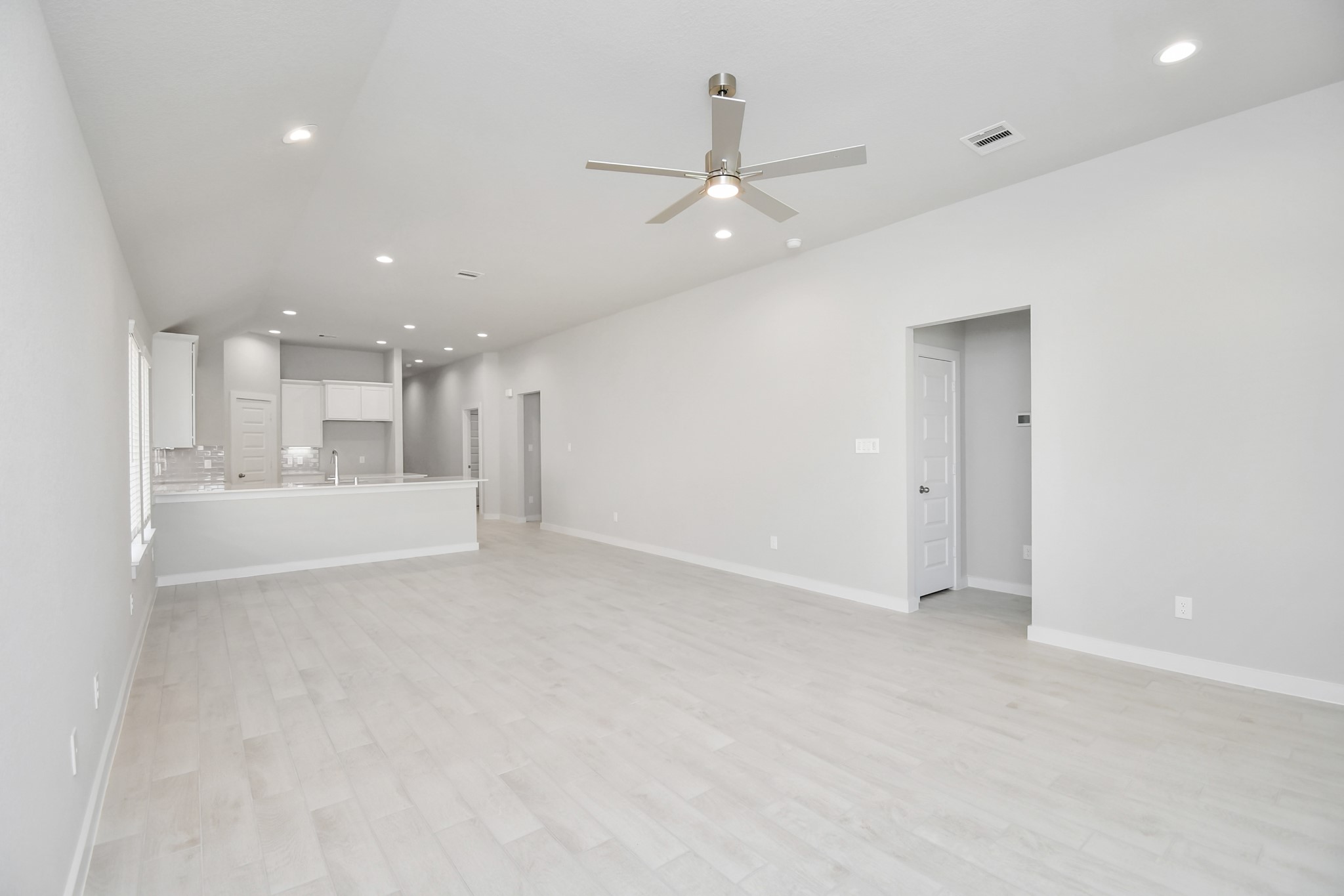 14619 Diamond Dove Lane Houston, TX 77049 - Photo 20 of 33 Relax and unwind in this inviting family room, illuminated by abundant natural light streaming in through tall windows, complemented by high ceilings and stunning flooring. Stay comfortable year-round with the gentle breeze from the ceiling fan, creating the perfect atmosphere for family gatherings. Sample photo of completed home with similar floor plan. Actual colors and selections may vary.