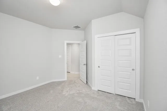 a sign that is sitting in the grass near a tree