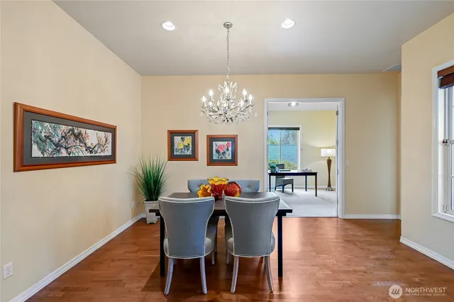 a dining room with furniture a chandelier and wooden floor