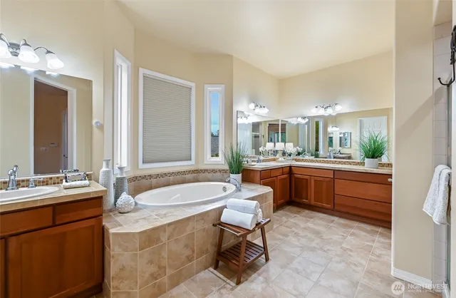 a large bathroom with a double vanity sink a mirror and a bathtub