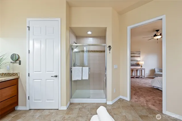 a bathroom with a glass shower door a sink and a mirror