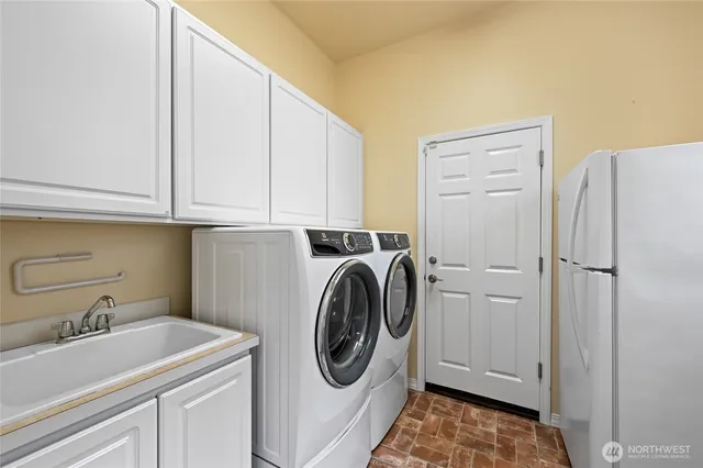 a utility room with sink dryer and washer