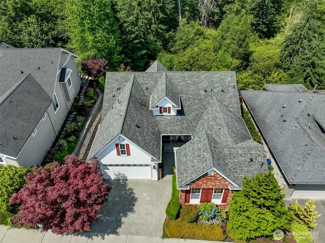 an aerial view of a house with a yard and large tree