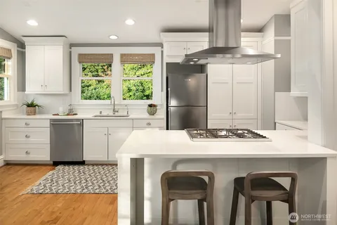 a kitchen with a stove a sink a refrigerator and a window