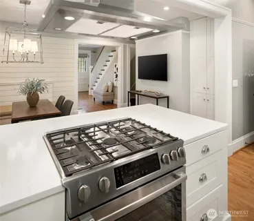 a view of kitchen island with stainless steel appliances wooden floor and counter top space