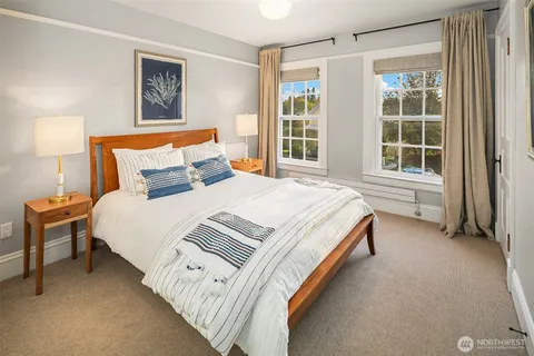 a bed sitting in a bedroom next to a window