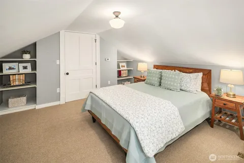 a spacious bedroom with a bed and a lamp