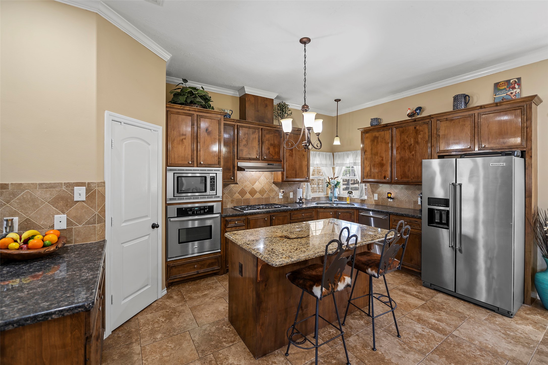 23530 Hargrave Road Hockley, TX 77447 - Photo 25 of 46 a kitchen with stainless steel appliances granite countertop a table chairs stove and refrigerator