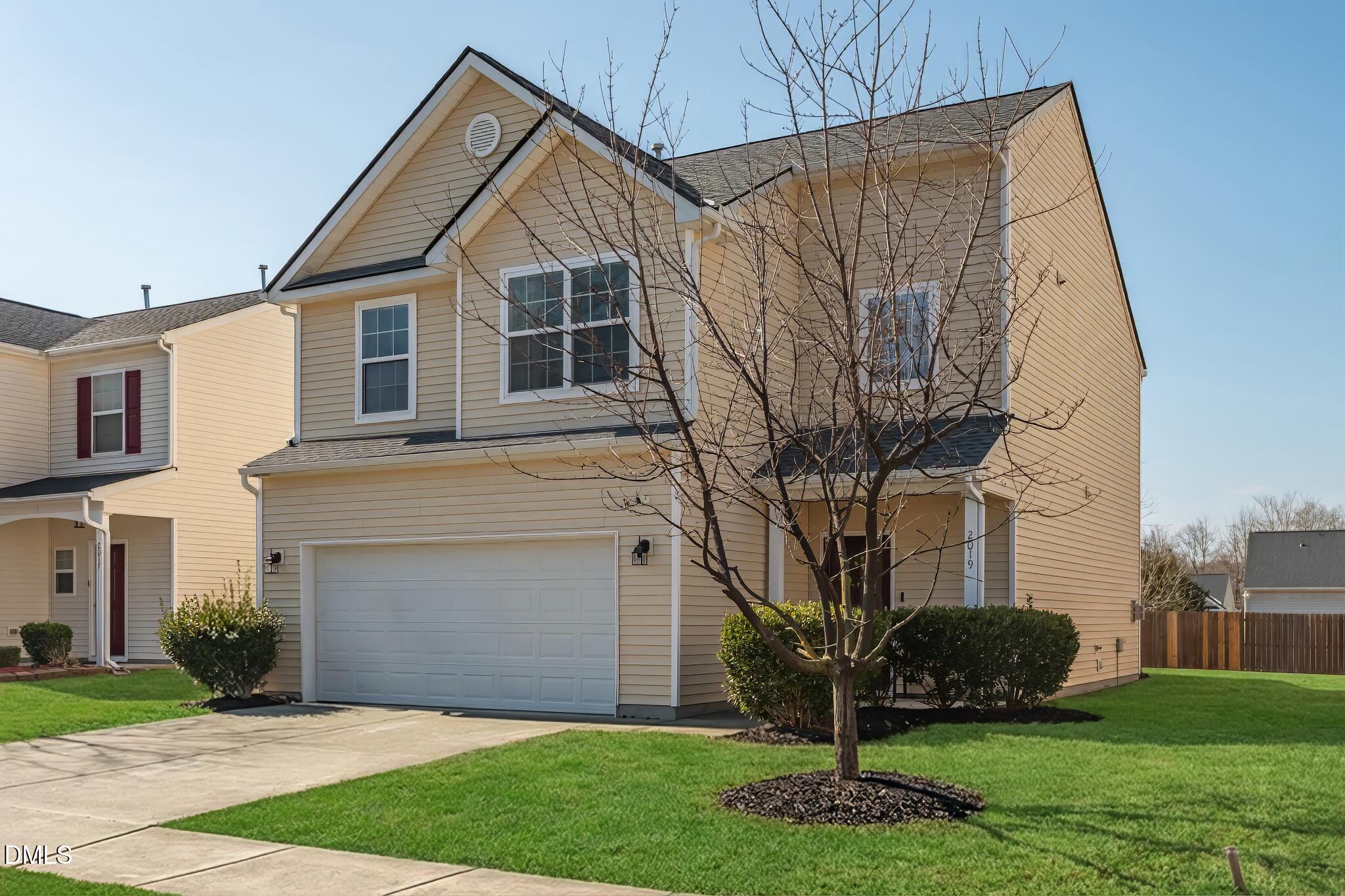 a front view of a house with a yard and garage
