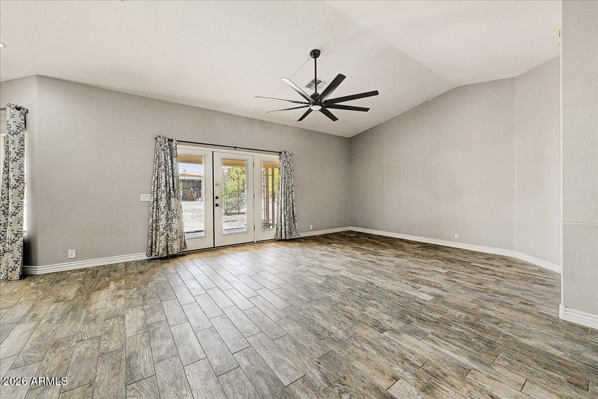 7624 North Citrus Road Waddell, AZ 85355 - Photo 9 of 57 a view of an empty room with a window and wooden floor