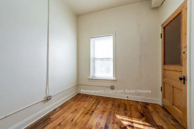a view of a room with wooden floor and a window