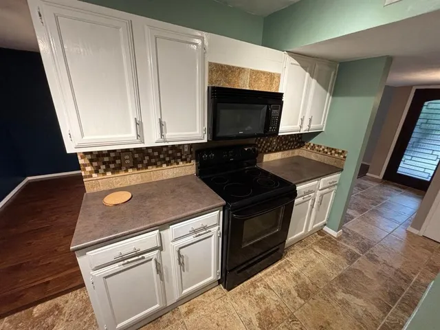 a stove top oven sitting inside of a kitchen