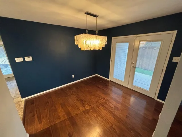 a view of a livingroom with a chandelier fan and wooden floor