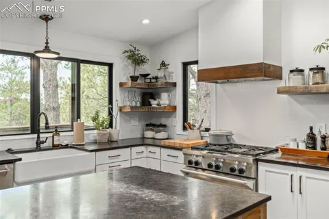 a kitchen with stainless steel appliances granite countertop a sink stove and cabinets