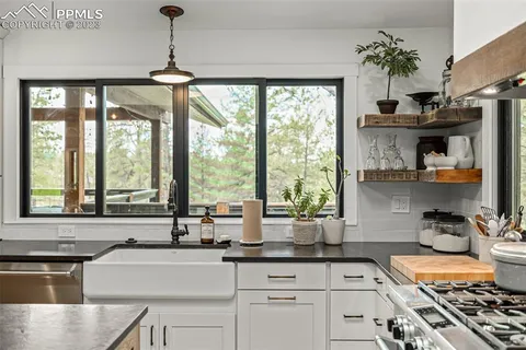 a kitchen with stainless steel appliances a sink a stove and a large window
