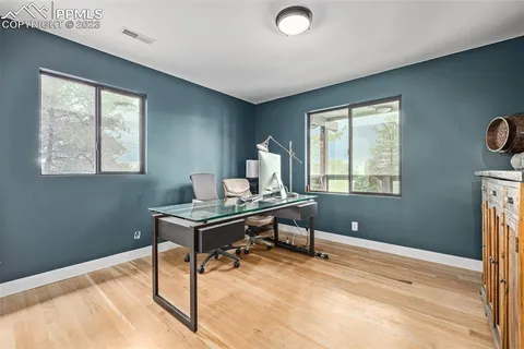 a view of a workspace with furniture and a window