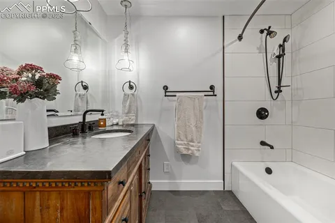 a bathroom with a granite countertop sink a toilet and shower