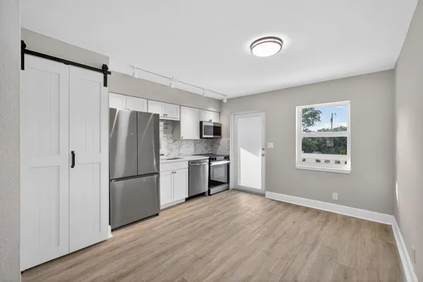 a kitchen with a refrigerator and a stove top oven