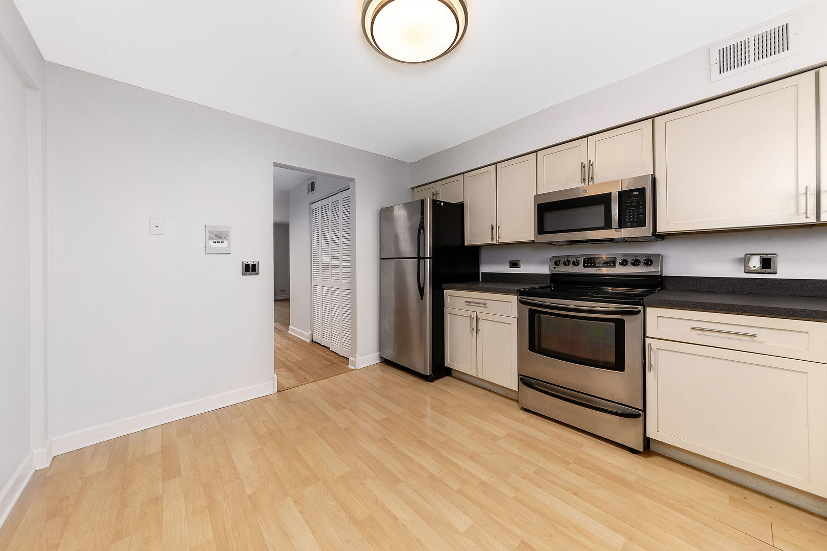 912 South Plum Grove Road, Unit 121 Palatine, IL 60067 - Photo 3 of 11 a kitchen with stainless steel appliances a refrigerator stove and microwave