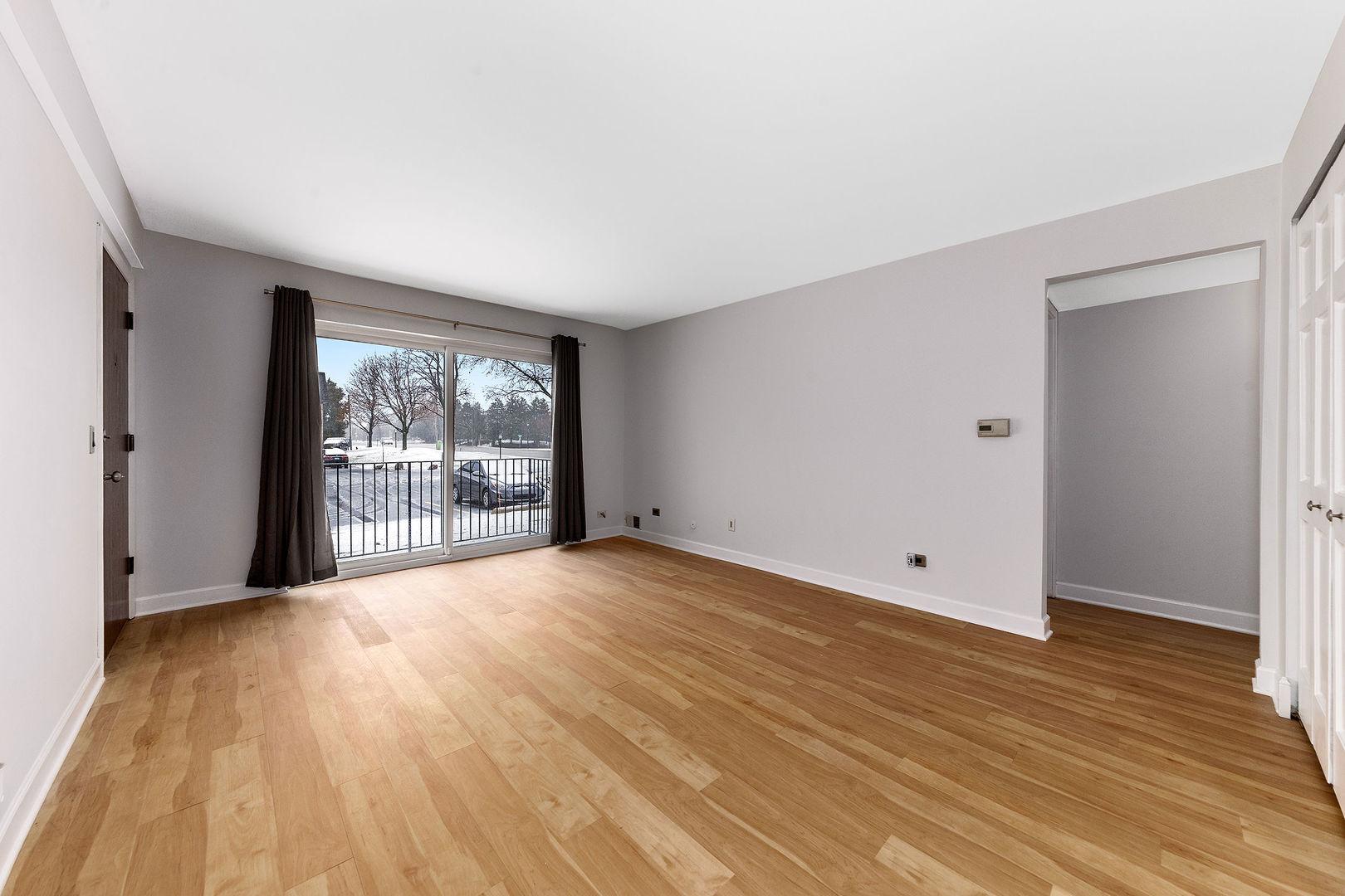 912 South Plum Grove Road, Unit 121 Palatine, IL 60067 - Photo 6 of 11 a view of an empty room with wooden floor and a window