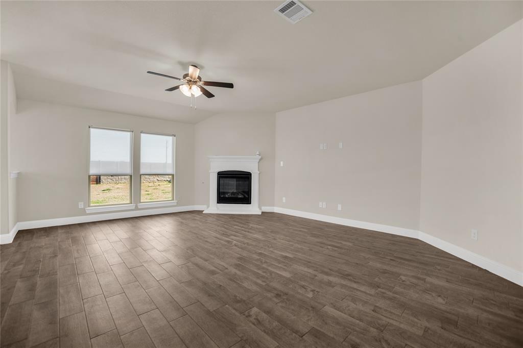 3616 Pinto Way Aubrey, TX 76227 - Photo 13 of 38 an empty room with wooden floor ceiling fan and windows