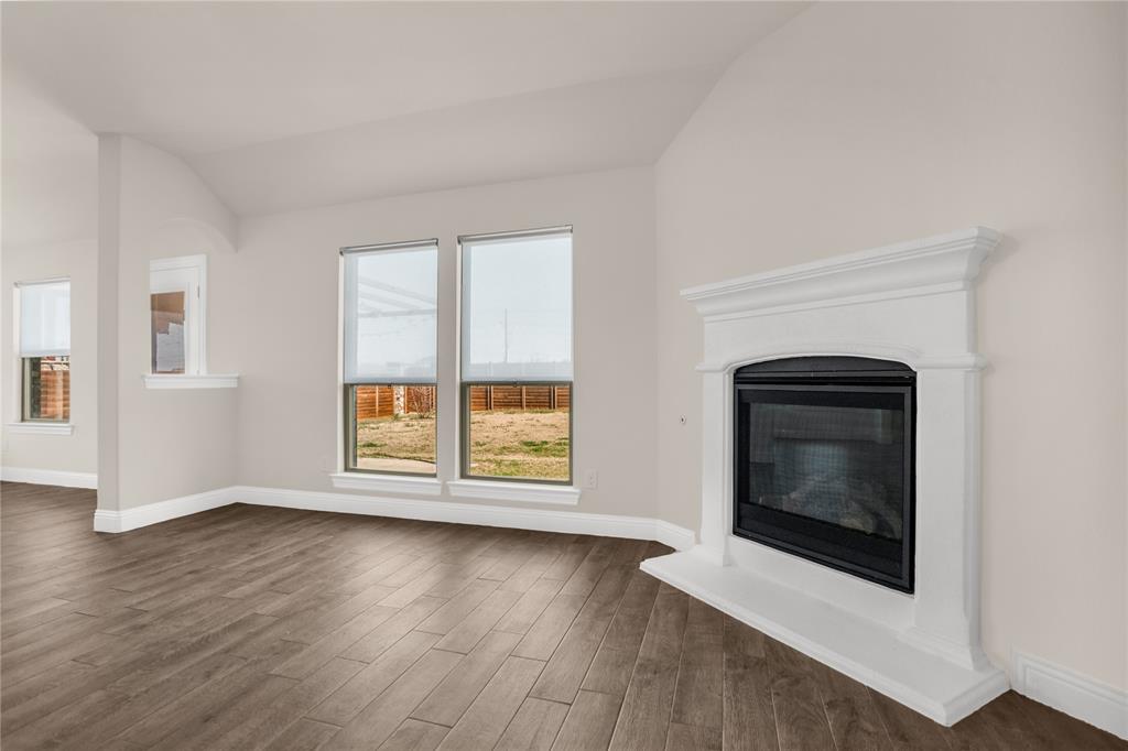 3616 Pinto Way Aubrey, TX 76227 - Photo 14 of 38 an empty room with wooden floor cabinet and windows