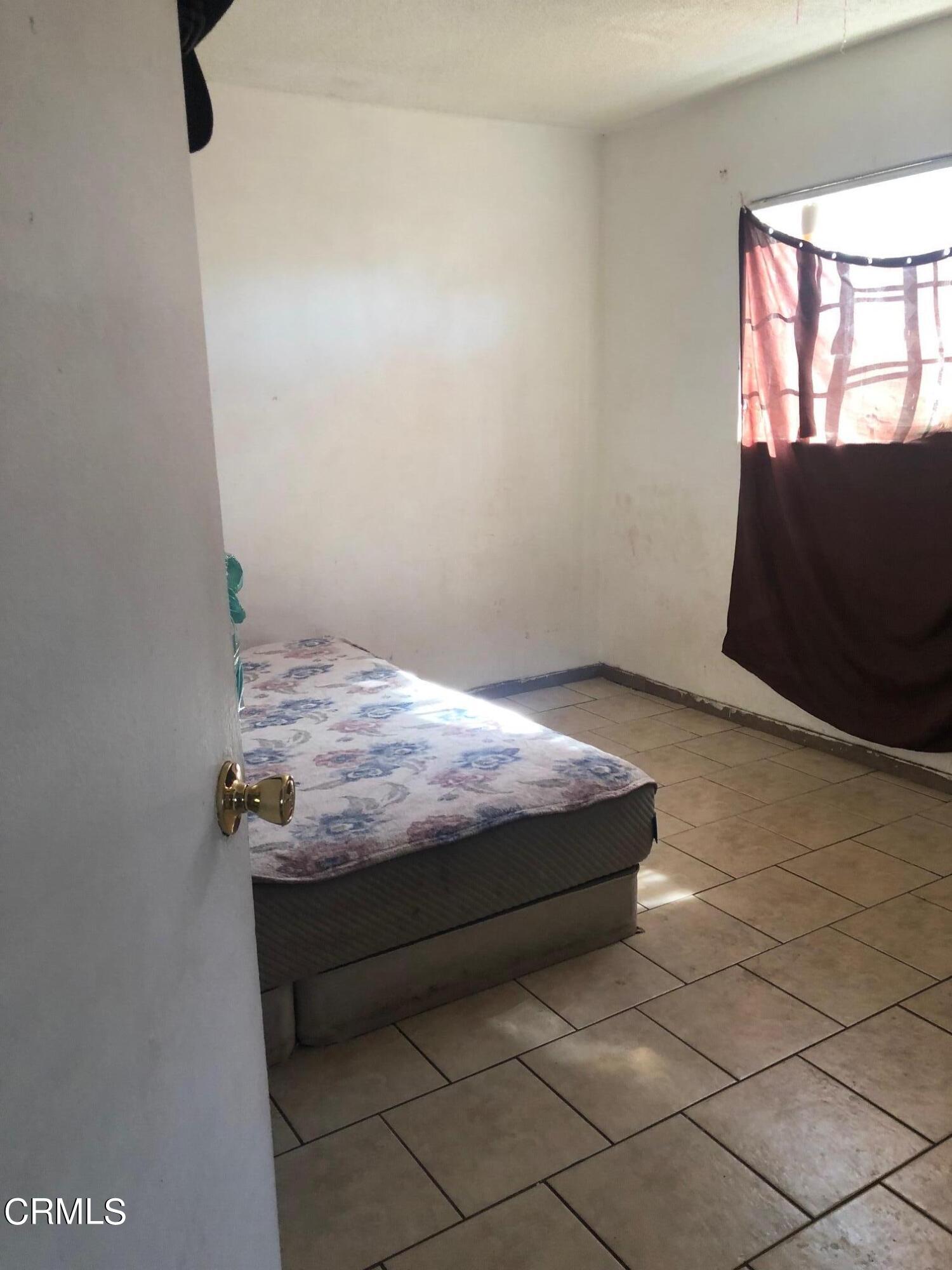 128 North Harrison Avenue Oxnard, CA 93030 - Photo 4 of 10 a bedroom with a bed and a window