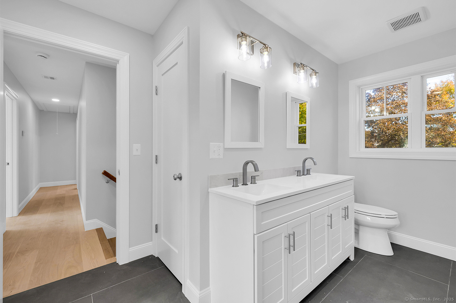 197 Vesper Street Fairfield, CT 06825 - Photo 16 of 21 a bathroom with a double vanity sink a toilet and a mirror