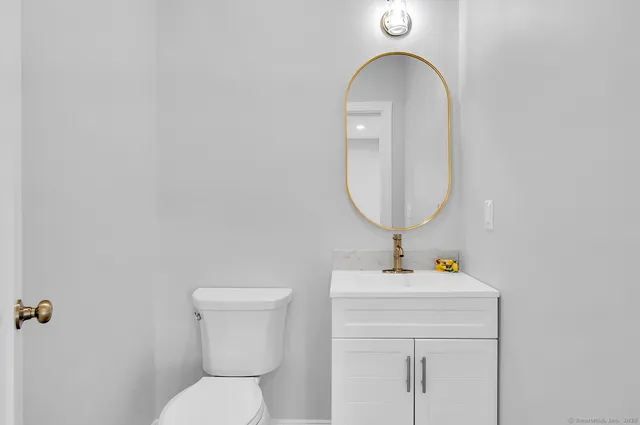 a bathroom with a toilet a sink and a mirror