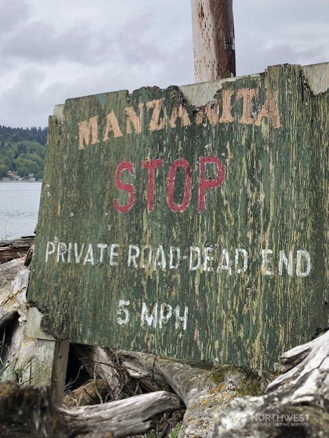 27728 Manzanita Beach Road Southwest Vashon, WA 98070 - Photo 16 of 17 a street sign that is on a brick wall