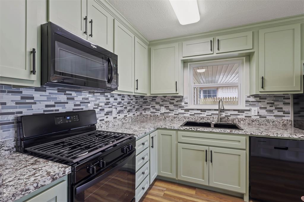 732 Bullock Street Denison, TX 75020 - Photo 9 of 29 a kitchen with granite countertop a stove sink and microwave