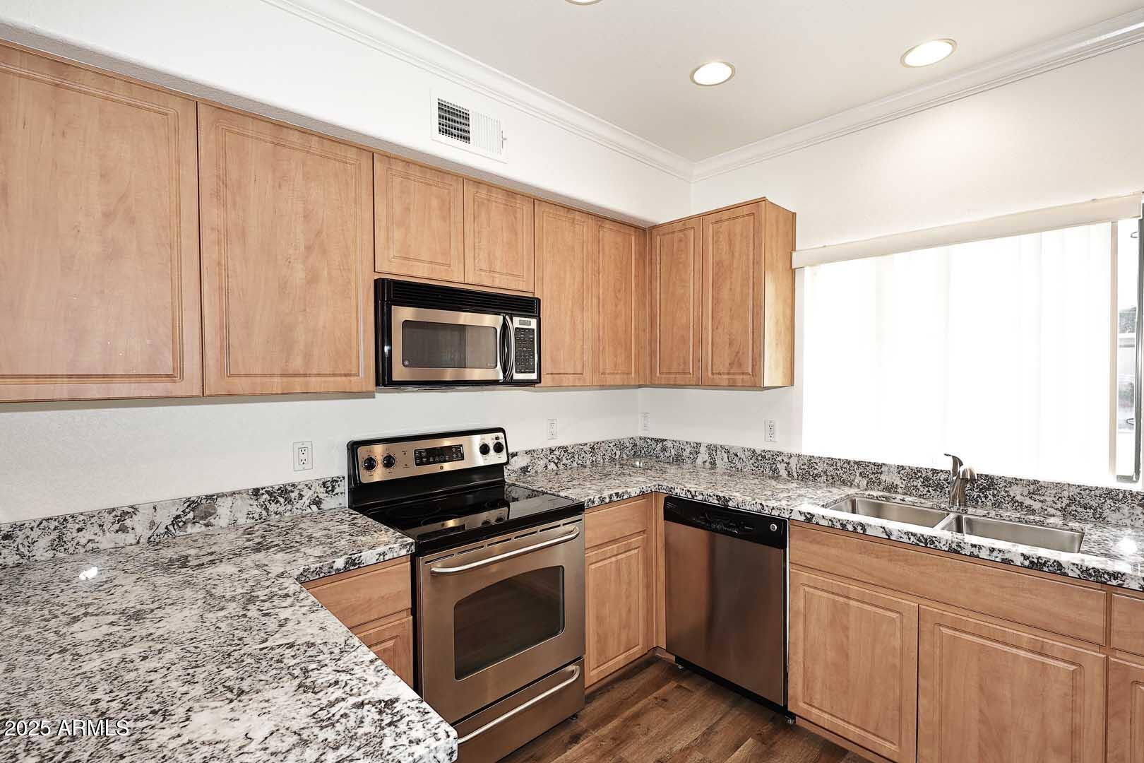 295 North Rural Road, Unit 164 Chandler, AZ 85226 - Photo 11 of 24 a kitchen with stainless steel appliances granite countertop a stove a sink and a microwave