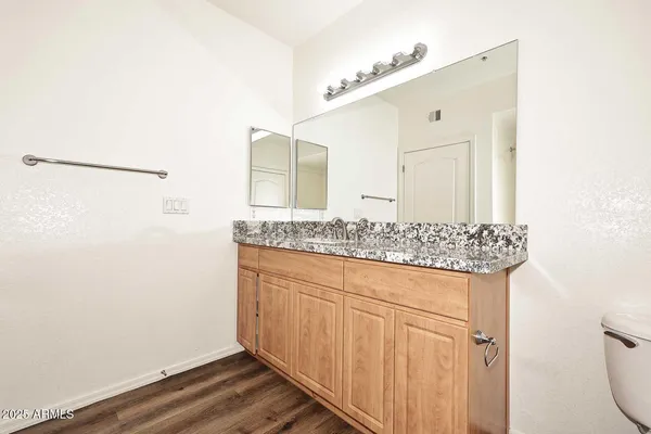 a bathroom with a granite countertop sink and a mirror