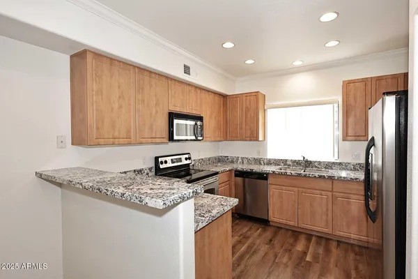 a kitchen with stainless steel appliances granite countertop a stove a sink and a refrigerator