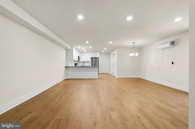a view of an empty room with wooden floor