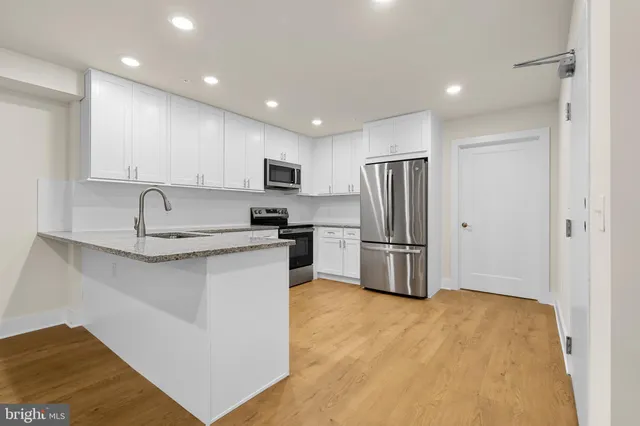 a kitchen with stainless steel appliances granite countertop a refrigerator sink and stove