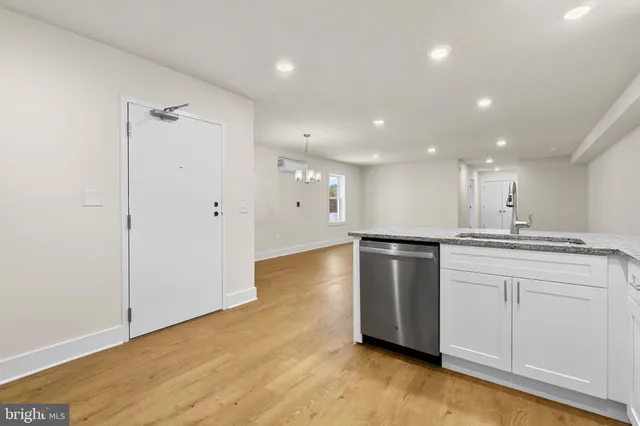 a view of a kitchen with a sink and dishwasher a refrigerator with wooden floor