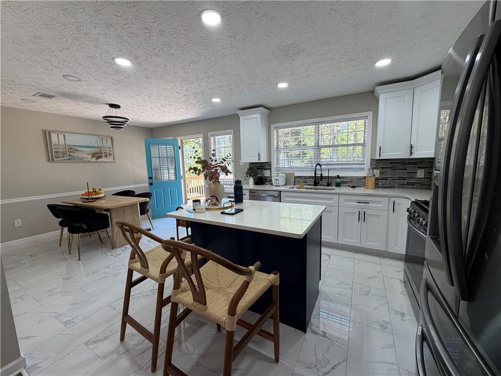 934 Bay Ridge Drive Lawrenceville, GA 30045 - Photo 22 of 78 a kitchen with a sink dining table and chairs