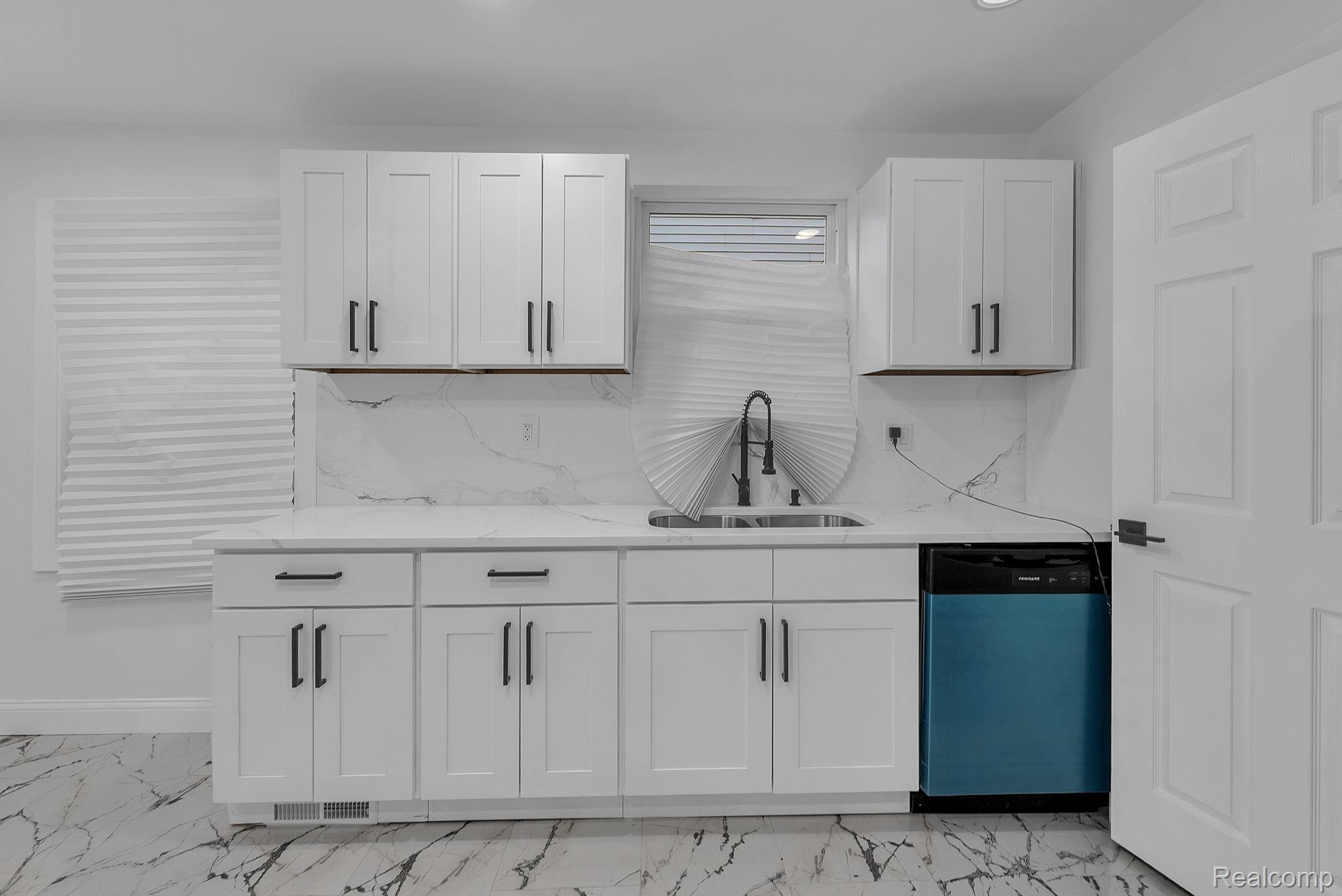4113 Devonshire Road Detroit, MI 48224 - Photo 17 of 36 Kitchen featuring dishwashing machine, white cabinets, light stone counters, and tasteful backsplash