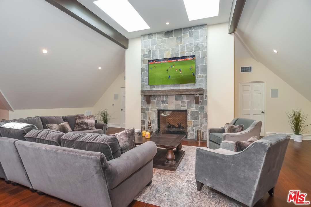 3901 Longridge Avenue Sherman Oaks, CA 91423 - Photo 37 of 51 a living room with furniture a flat screen tv and a fireplace