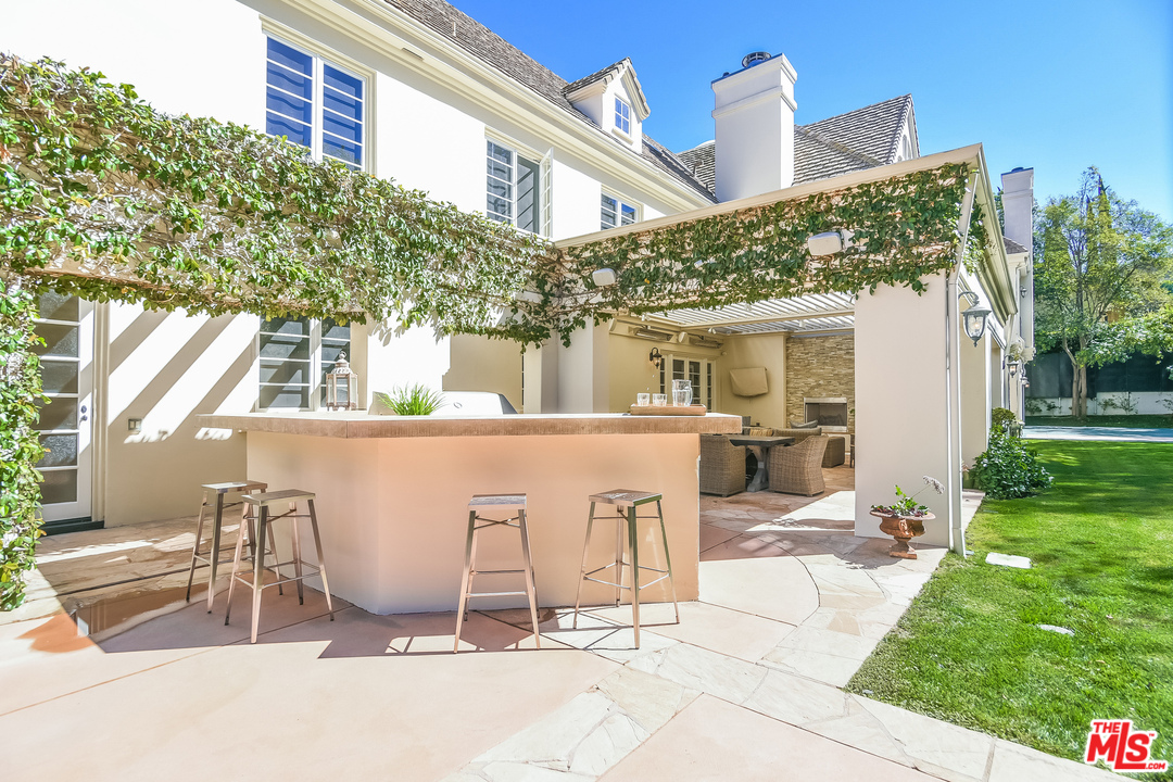3901 Longridge Avenue Sherman Oaks, CA 91423 - Photo 45 of 51 a view of a patio with table and chairs near a yard
