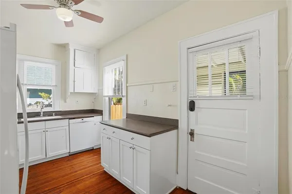 a kitchen with granite countertop cabinets a sink a window and stainless steel appliances