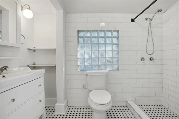 a bathroom with a sink toilet a mirror and shower