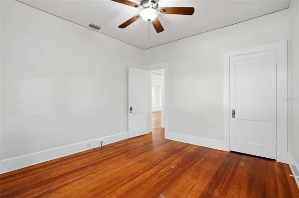 a view of an empty room with wooden floor