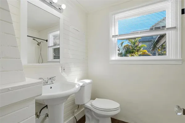 a bathroom with a sink a toilet and a window