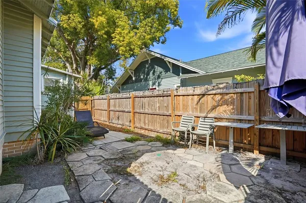 a backyard of a house with table and chairs