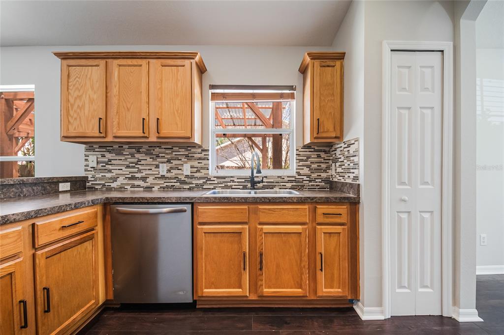 221 Rosa Avenue Oviedo, FL 32765 - Photo 11 of 36 a kitchen with stainless steel appliances granite countertop wooden cabinets a sink and dishwasher with wooden floor