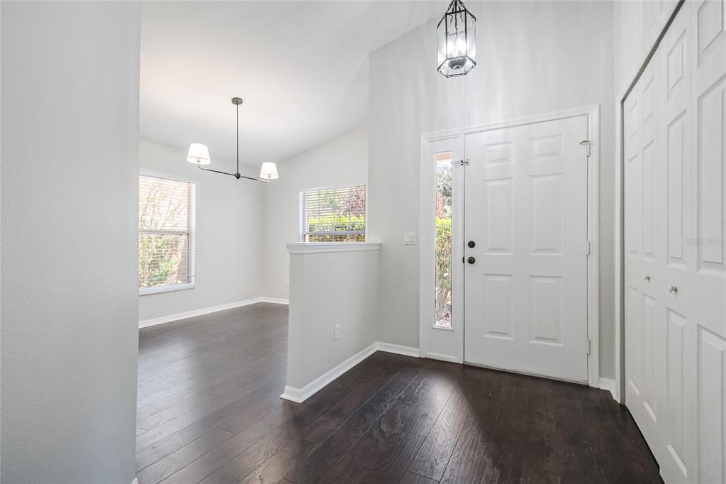 221 Rosa Avenue Oviedo, FL 32765 - Photo 7 of 36 an empty room with wooden floor mirror and windows