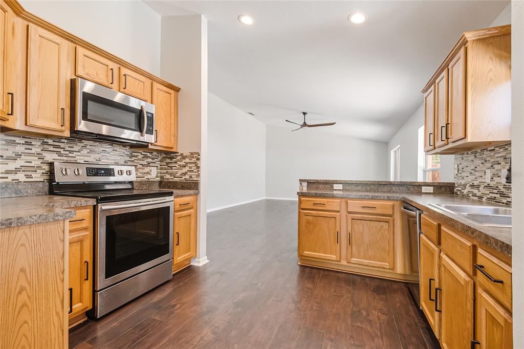 221 Rosa Avenue Oviedo, FL 32765 - Photo 10 of 36 a kitchen with stainless steel appliances granite countertop a stove microwave sink and cabinets