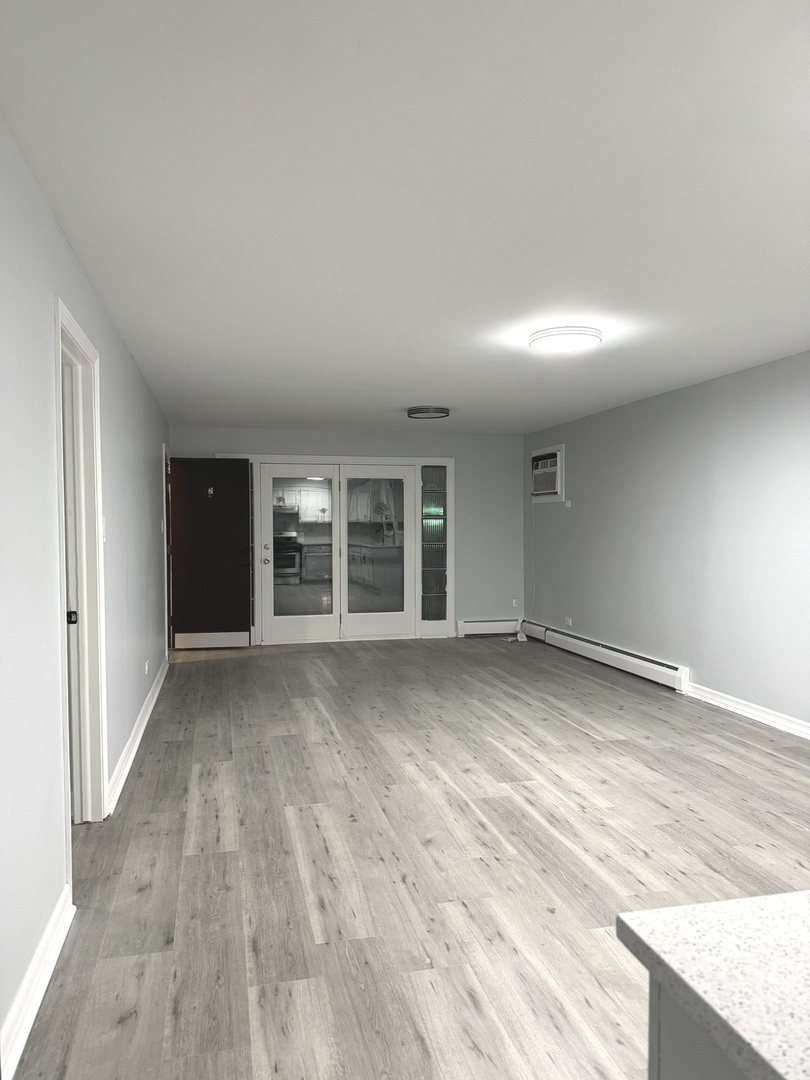 82 Luella Avenue, Unit 2 Calumet City, IL 60409 - Photo 12 of 12 an empty room with wooden floor and windows